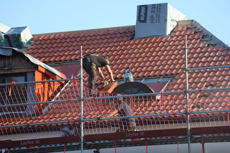 Roofer installing new shingles during a roof replacement project