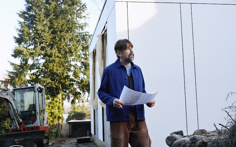 Contractor reviewing roofing plans outside a home during a consultation