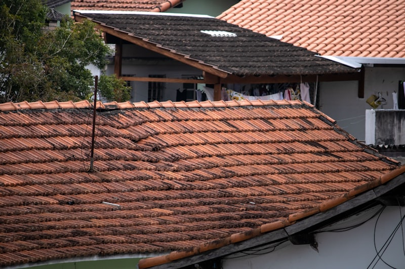 Weathered residential roof with missing and wind-damaged shingles
